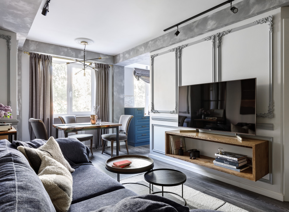 Стильный дизайн: гостиная комната среднего размера в современном стиле с белыми стенами, темным паркетным полом, отдельно стоящим телевизором, черным полом и синим диваном - последний тренд