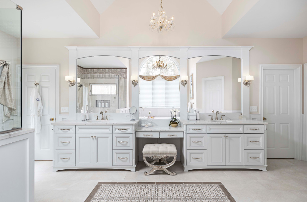 Photo of an expansive traditional master bathroom in Detroit with recessed-panel cabinets, white cabinets, a freestanding tub, a corner shower, a bidet, white tile, porcelain tile, beige walls, porcelain floors, an undermount sink, engineered quartz benchtops, beige floor, a hinged shower door, white benchtops, an enclosed toilet, a double vanity, a built-in vanity, vaulted and decorative wall panelling.