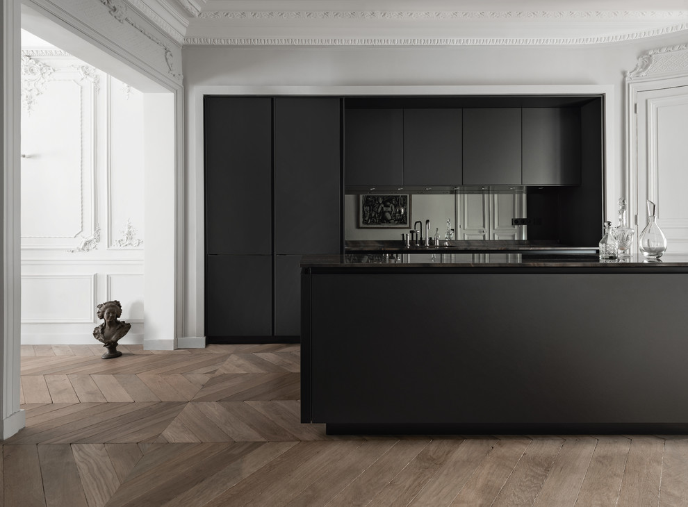 Inspiration for a large contemporary single-wall eat-in kitchen in Munich with flat-panel cabinets, black cabinets, marble benchtops, black splashback, mirror splashback, medium hardwood floors and with island.