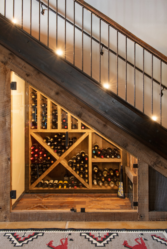 Design ideas for a mid-sized country wine cellar in Other with medium hardwood floors, diamond bins and brown floor.