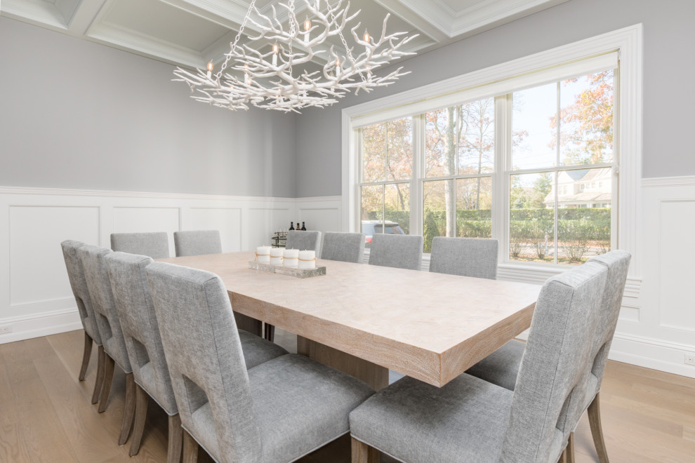 Enclosed dining room - transitional light wood floor, coffered ceiling and wainscoting enclosed dining room idea in New York