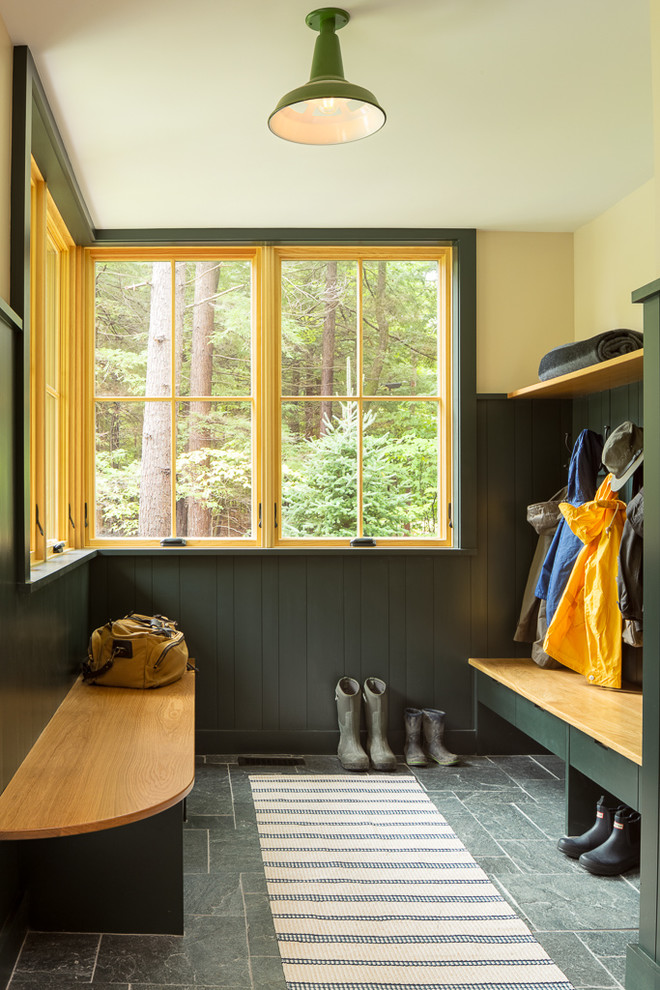 This is an example of a country mudroom in Portland Maine with yellow walls and grey floor.