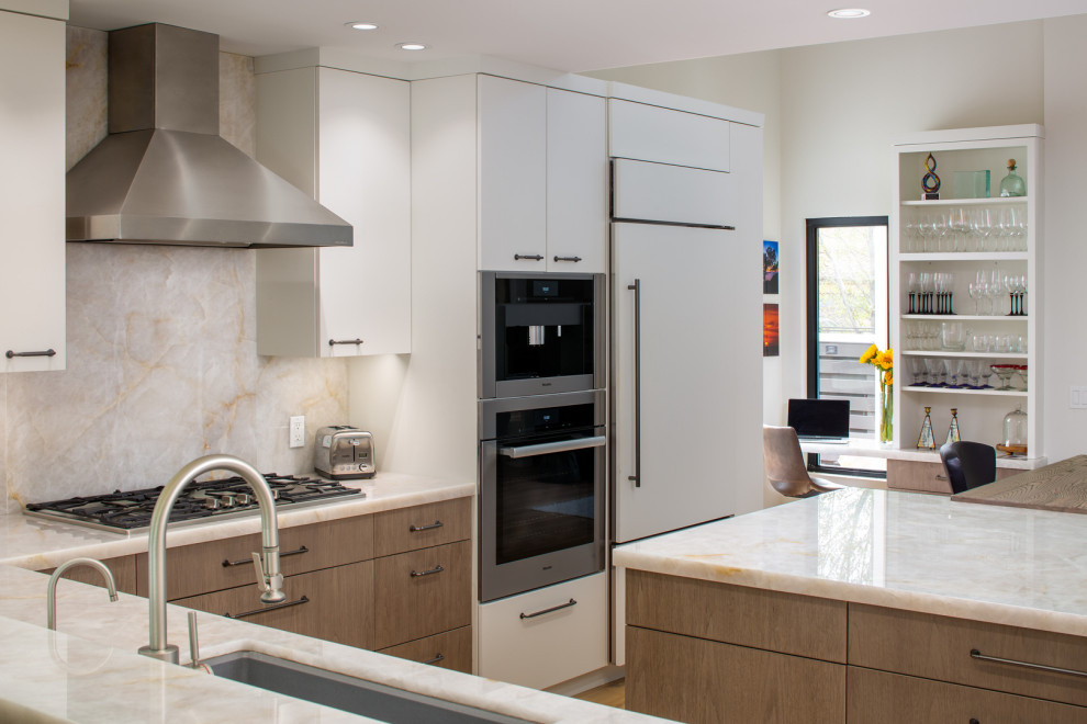 Photo of a large contemporary l-shaped kitchen/diner in San Diego with a submerged sink, flat-panel cabinets, white cabinets, quartz worktops, white splashback, stone slab splashback, stainless steel appliances, light hardwood flooring, an island, white floors and white worktops.