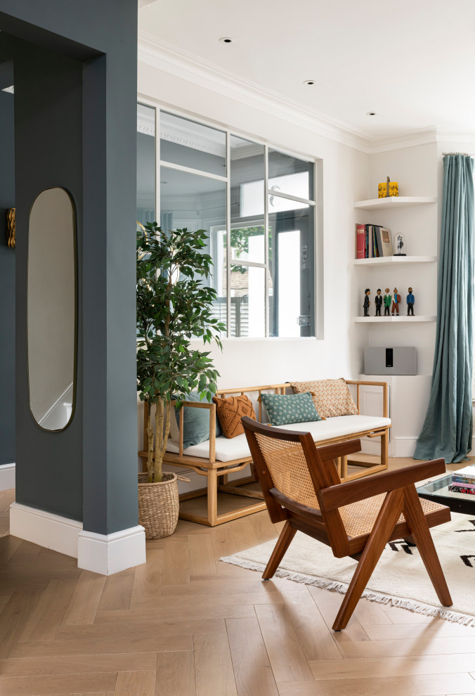 Foto de salón para visitas cerrado bohemio de tamaño medio sin chimenea y televisor con paredes azules, suelo de madera clara y suelo beige