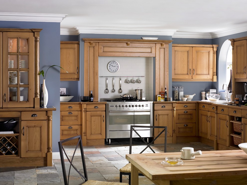 This is an example of a large traditional l-shaped eat-in kitchen in Other with shaker cabinets, medium wood cabinets, wood benchtops, white splashback, stainless steel appliances, slate floors, no island and grey floor.