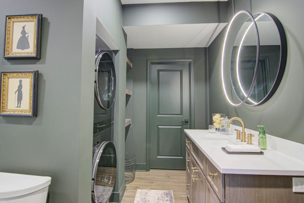 This is an example of a large modern 3/4 bathroom in Kansas City with shaker cabinets, medium wood cabinets, a two-piece toilet, green walls, vinyl floors, an undermount sink, engineered quartz benchtops, a sliding shower screen, white benchtops, a laundry, a single vanity and a built-in vanity.