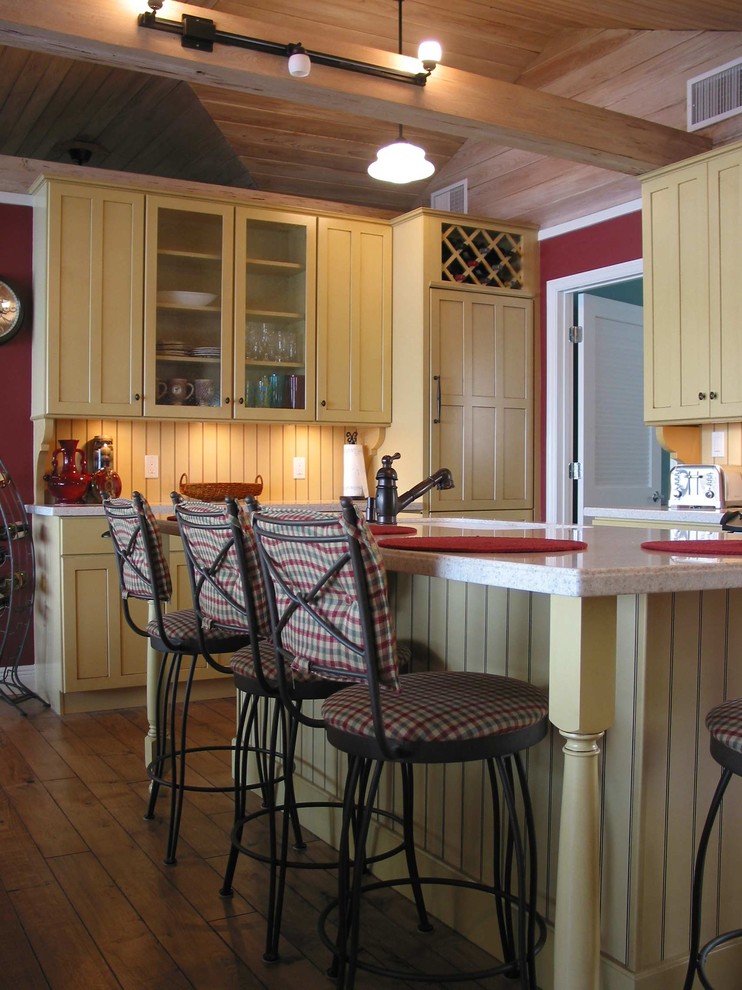 Inspiration for a mid-sized transitional u-shaped eat-in kitchen in Orlando with an undermount sink, shaker cabinets, yellow cabinets, terrazzo benchtops, yellow splashback, timber splashback, panelled appliances, medium hardwood floors, with island, brown floor and multi-coloured benchtop.