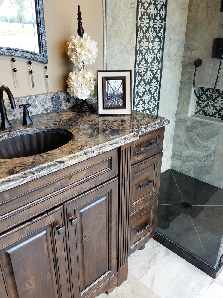 Design ideas for a mid-sized traditional 3/4 bathroom in Wichita with raised-panel cabinets, dark wood cabinets, a corner shower, multi-coloured tile, stone tile, brown walls, marble floors, an undermount sink, granite benchtops, multi-coloured floor and a hinged shower door.