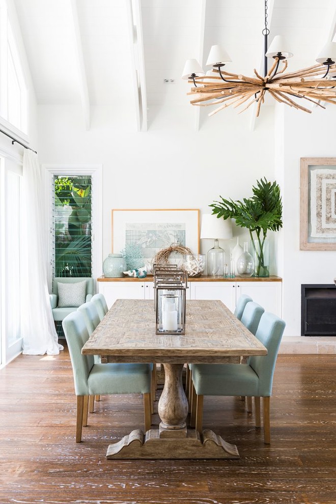 Design ideas for a beach style open plan dining in Gold Coast - Tweed with white walls, painted wood floors, a standard fireplace and brown floor.