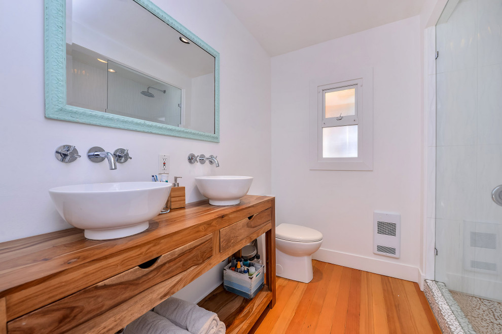 Foto på ett mellanstort retro brun en-suite badrum, med en öppen dusch, en toalettstol med hel cisternkåpa, vit kakel, kakel i småsten, vita väggar, mellanmörkt trägolv, ett fristående handfat, träbänkskiva, orange golv och med dusch som är öppen
