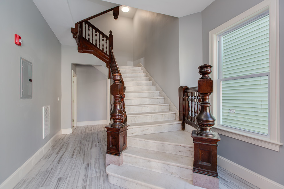 Inspiration for a large traditional marble u-shaped staircase in Boston with marble risers and wood railing.