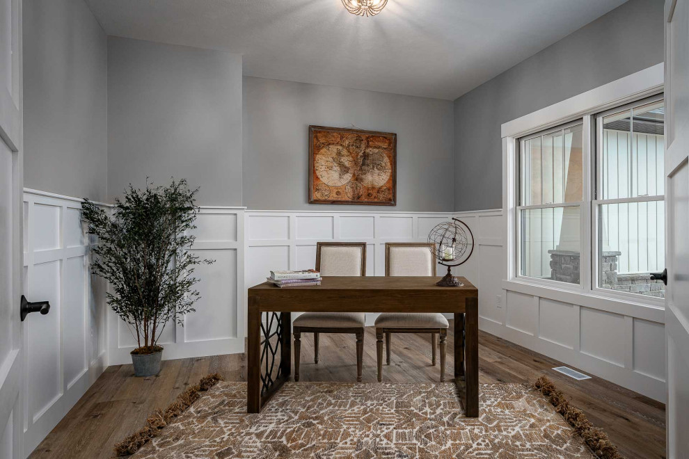 Medium sized traditional study in Other with multi-coloured walls, vinyl flooring, no fireplace, a freestanding desk, brown floors and wainscoting.