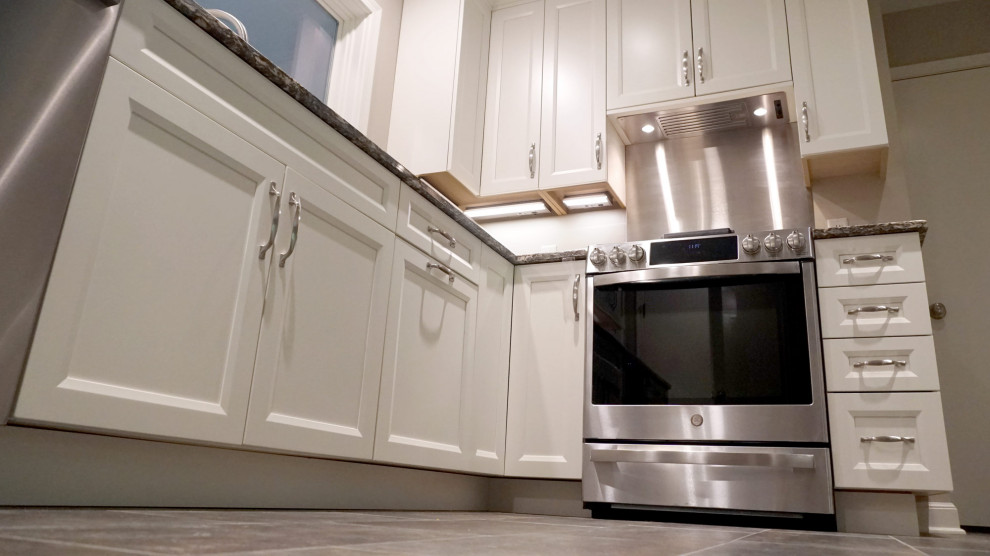 Minimalist u-shaped porcelain tile and brown floor eat-in kitchen photo with an undermount sink, shaker cabinets, white cabinets, quartz countertops, stainless steel appliances, a peninsula and multicolored countertops