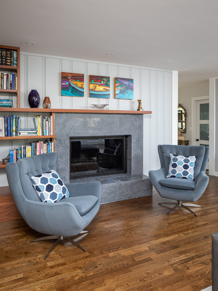 Mittelgroßes, Offenes Modernes Wohnzimmer mit weißer Wandfarbe, braunem Holzboden, Kaminofen, Kaminumrandung aus Beton, braunem Boden und Holzwänden in Raleigh