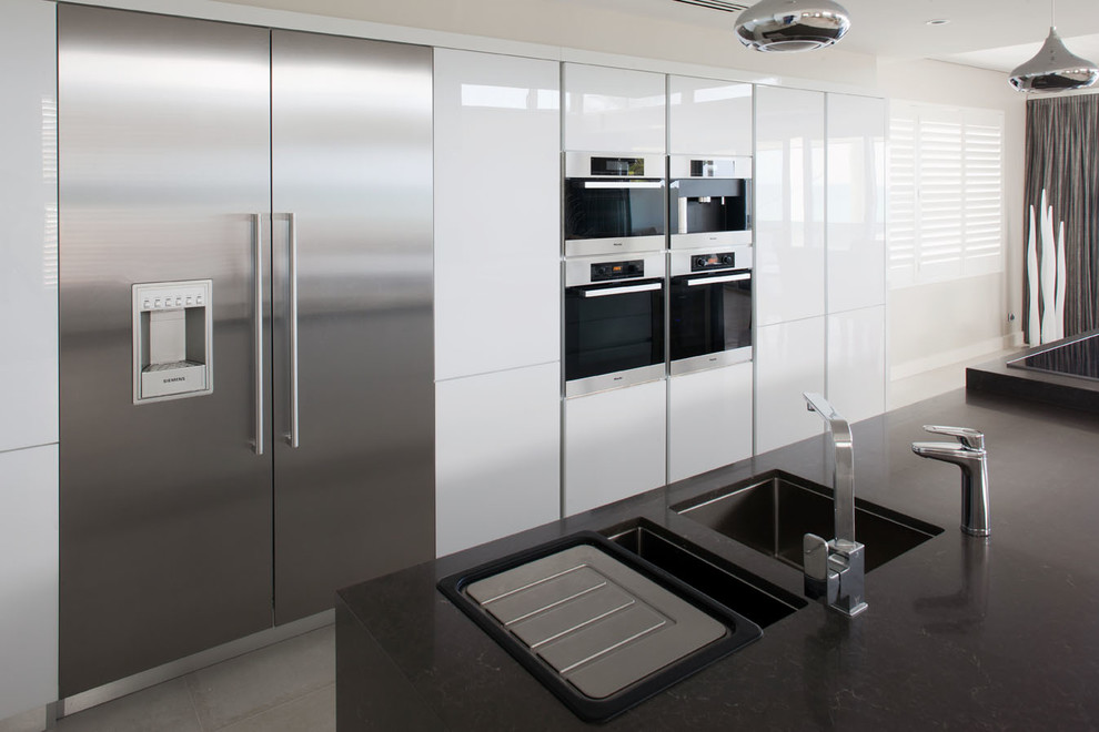 Large modern galley eat-in kitchen in Perth with an undermount sink, white cabinets, quartz benchtops, stainless steel appliances, porcelain floors and with island.