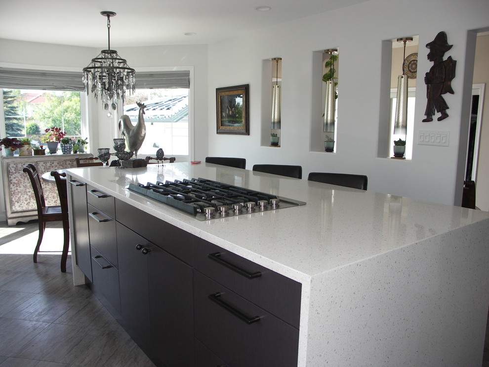 Mid-sized contemporary l-shaped eat-in kitchen in Edmonton with an undermount sink, flat-panel cabinets, grey cabinets, quartz benchtops, white splashback, glass tile splashback, stainless steel appliances, porcelain floors, with island and beige floor.