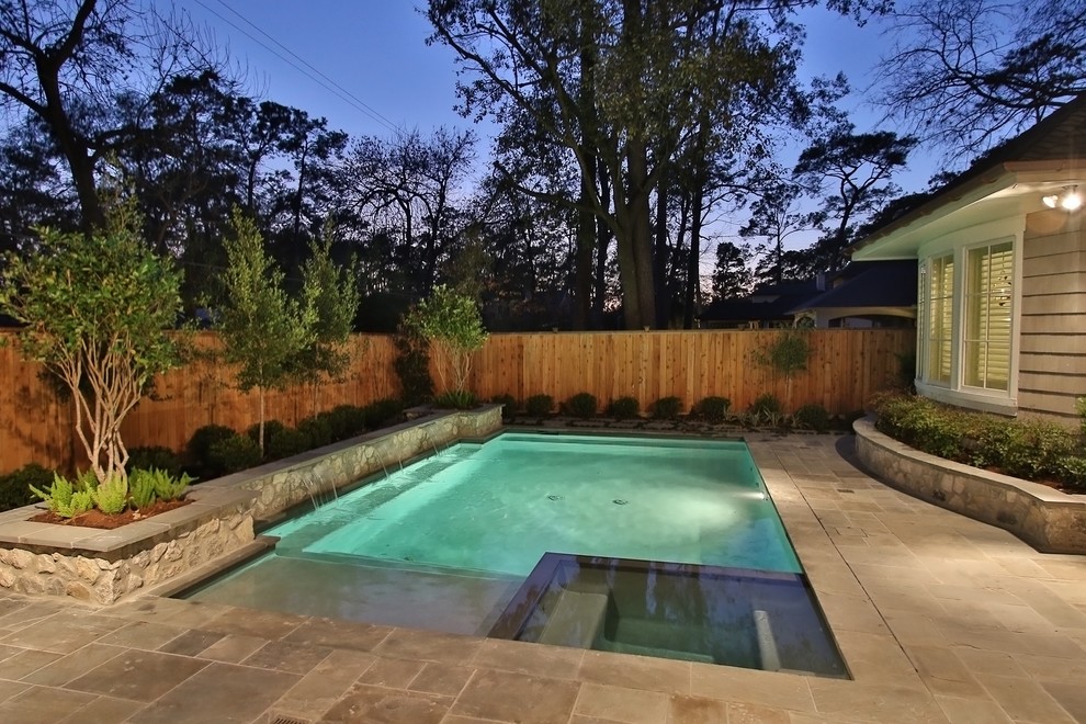 This is an example of a mid-sized traditional backyard rectangular natural pool in Houston with natural stone pavers.