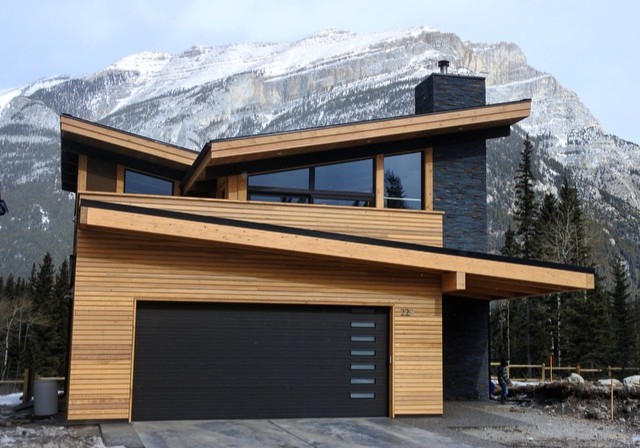 Inspiration for a mid-sized contemporary two-storey brown house exterior in Calgary with wood siding and a shed roof.