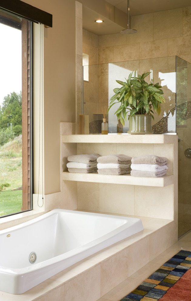 This is an example of a large contemporary bathroom in Portland with a drop-in tub, a corner shower, beige tile, beige walls and travertine floors.