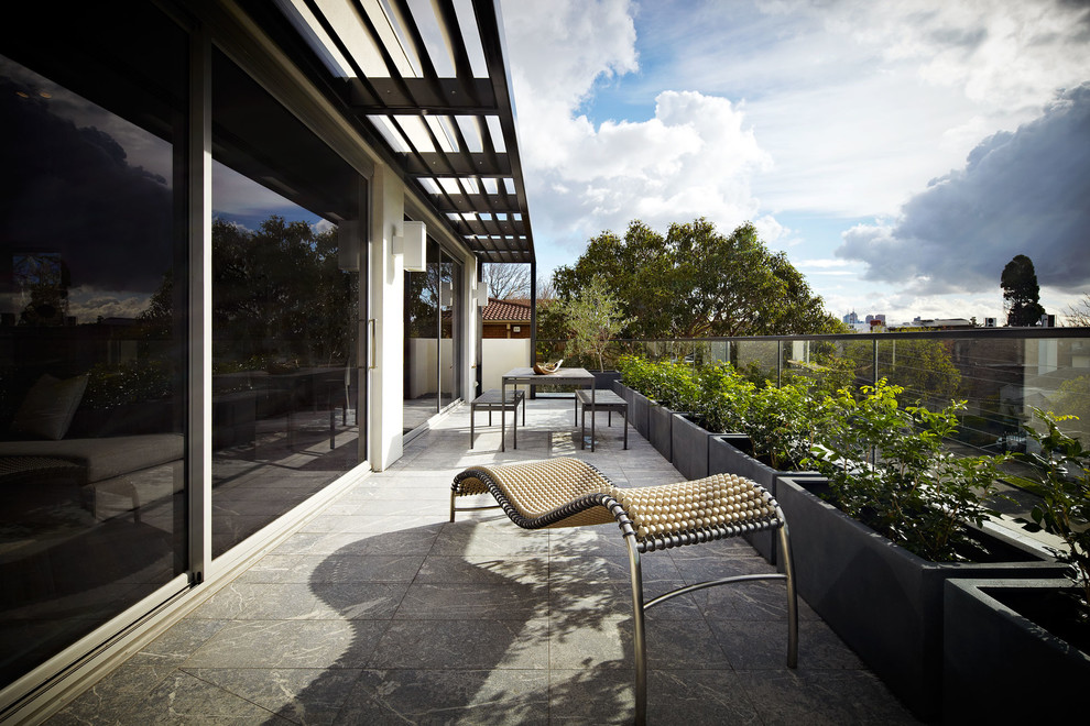 Inspiration for a mid-sized contemporary patio in Melbourne with a container garden and natural stone pavers.
