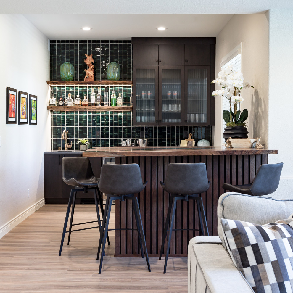 Inspiration for a large transitional laminate floor, beige floor and wall paneling basement remodel in Denver with a bar and green walls