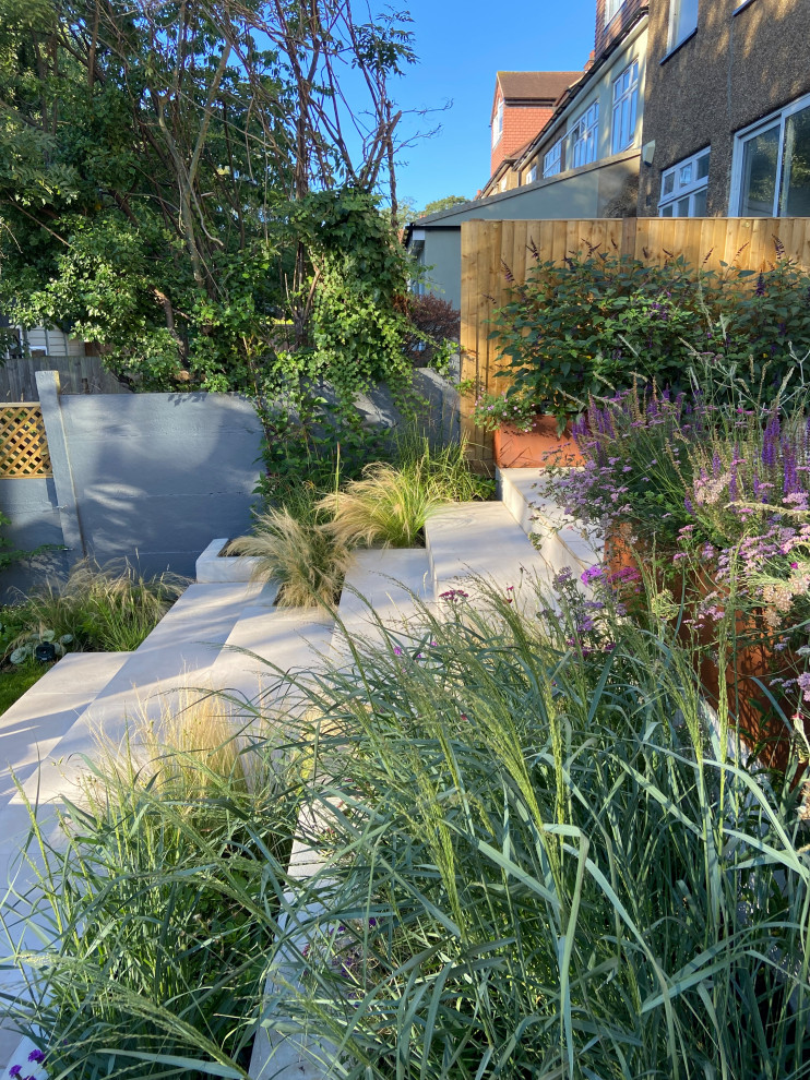 Foto di un piccolo giardino xeriscape contemporaneo esposto a mezz'ombra dietro casa in estate con scale e pavimentazioni in pietra naturale