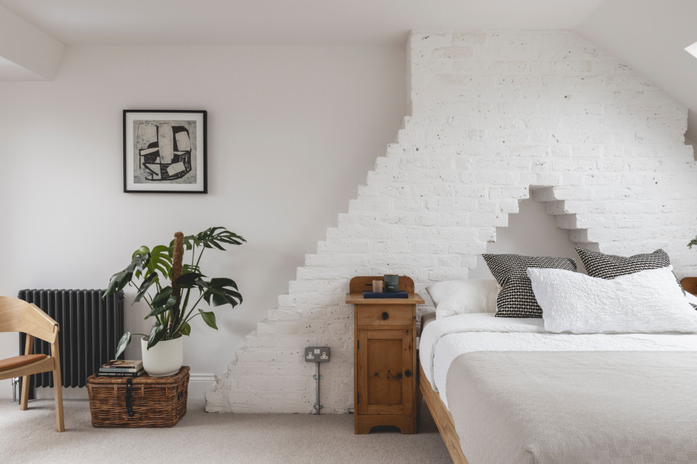 This is an example of a contemporary bedroom in London with white walls, carpet, grey floor and brick walls.