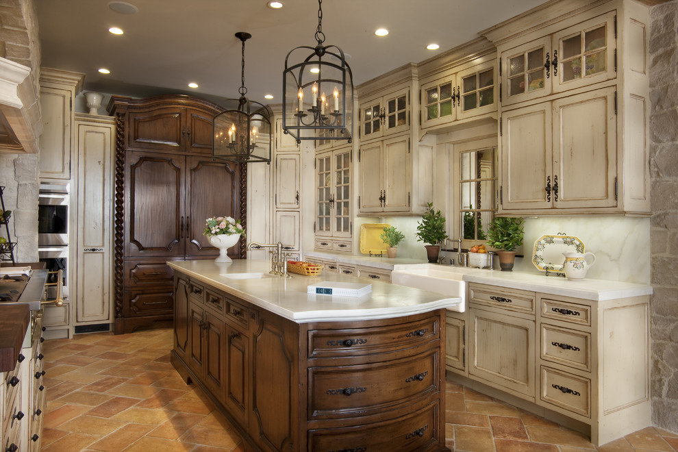 This is an example of a large mediterranean u-shaped separate kitchen in San Diego with a farmhouse sink, distressed cabinets, panelled appliances, recessed-panel cabinets, white splashback, marble splashback, marble benchtops, travertine floors, with island and brown floor.