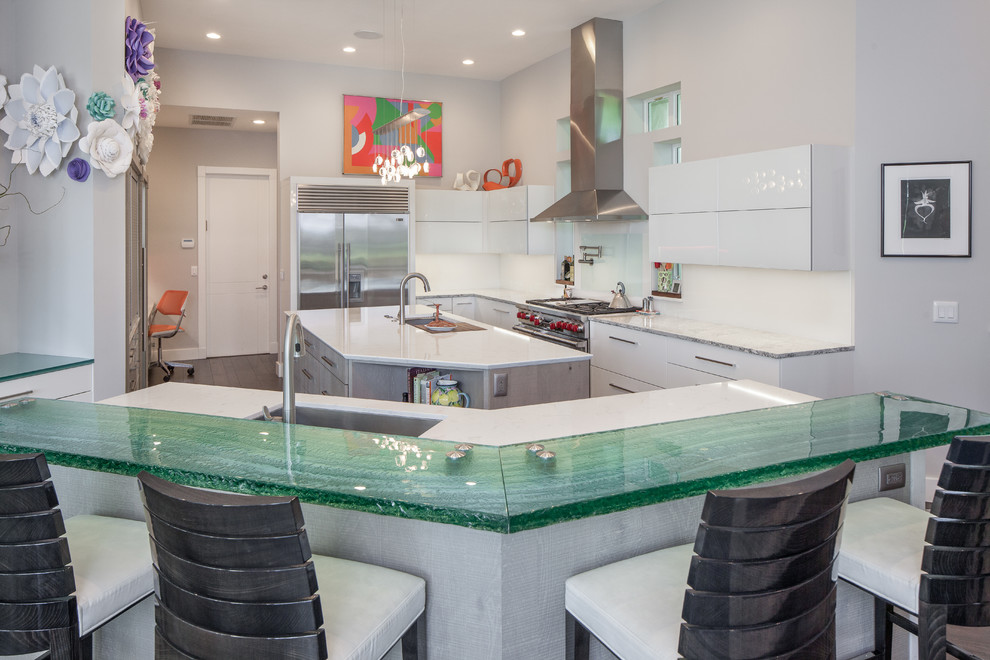 Inspiration for a contemporary u-shaped separate kitchen in Miami with an undermount sink, flat-panel cabinets, white cabinets, glass benchtops, white splashback, stainless steel appliances, dark hardwood floors, multiple islands and turquoise benchtop.