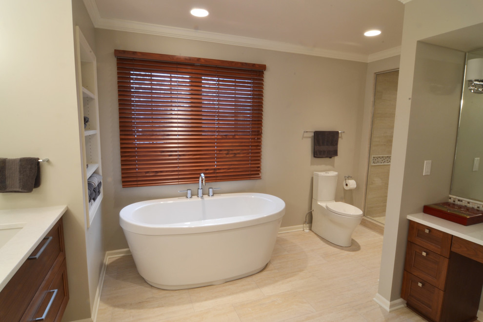 Large transitional master beige tile and porcelain tile porcelain tile freestanding bathtub photo with an undermount sink, flat-panel cabinets, medium tone wood cabinets, quartz countertops, a two-piece toilet and gray walls