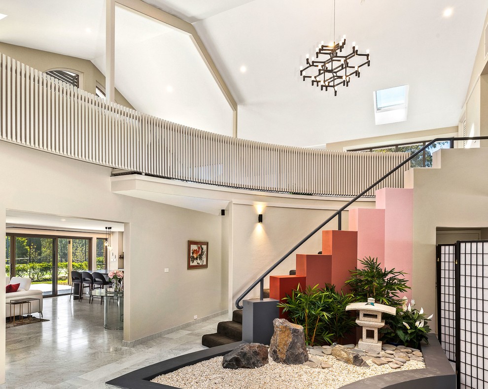 Expansive contemporary foyer in Sydney with beige walls and grey floor.