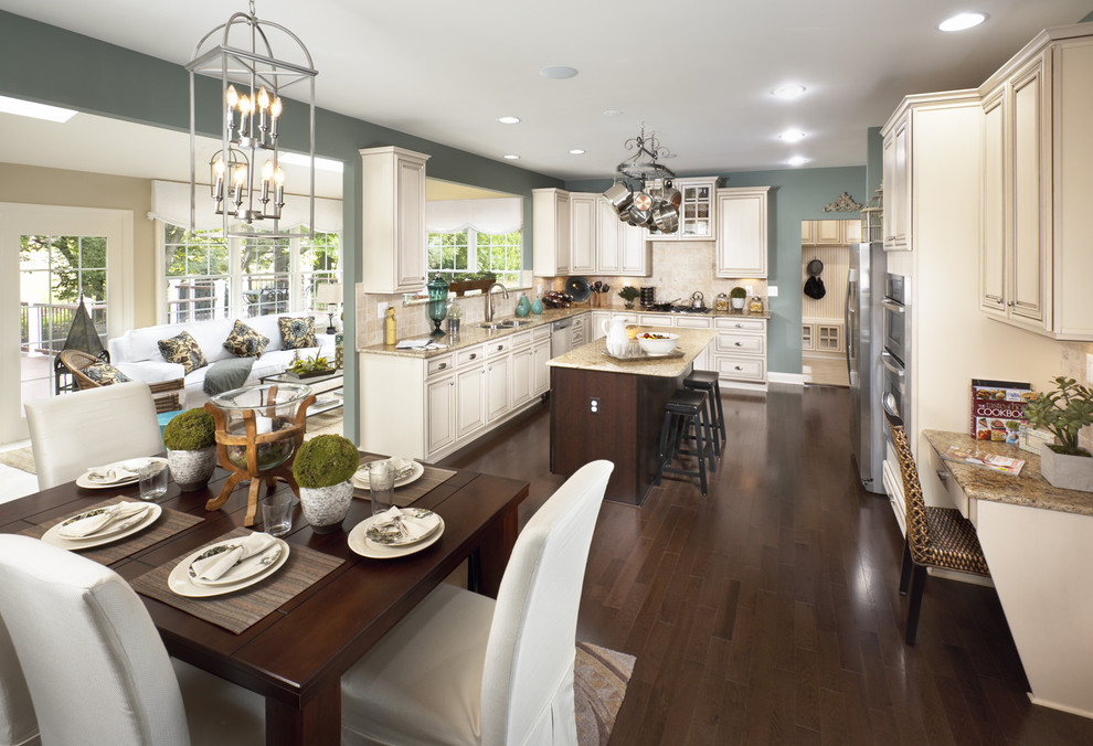 Example of a classic u-shaped open concept kitchen design with a double-bowl sink, beaded inset cabinets, beige cabinets, beige backsplash and stainless steel appliances