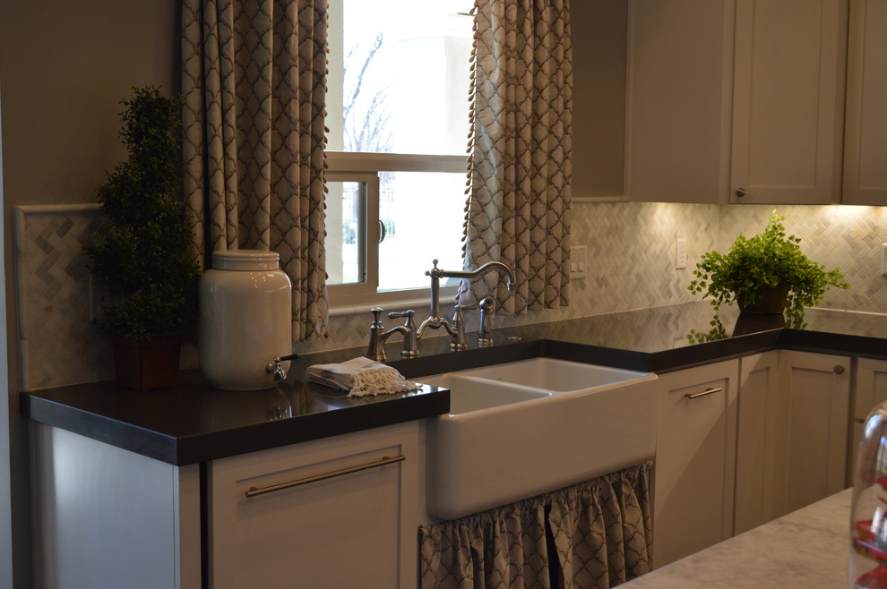 Example of a transitional porcelain tile kitchen design in Phoenix with a farmhouse sink, glass-front cabinets, white cabinets, quartz countertops, gray backsplash, mosaic tile backsplash and an island