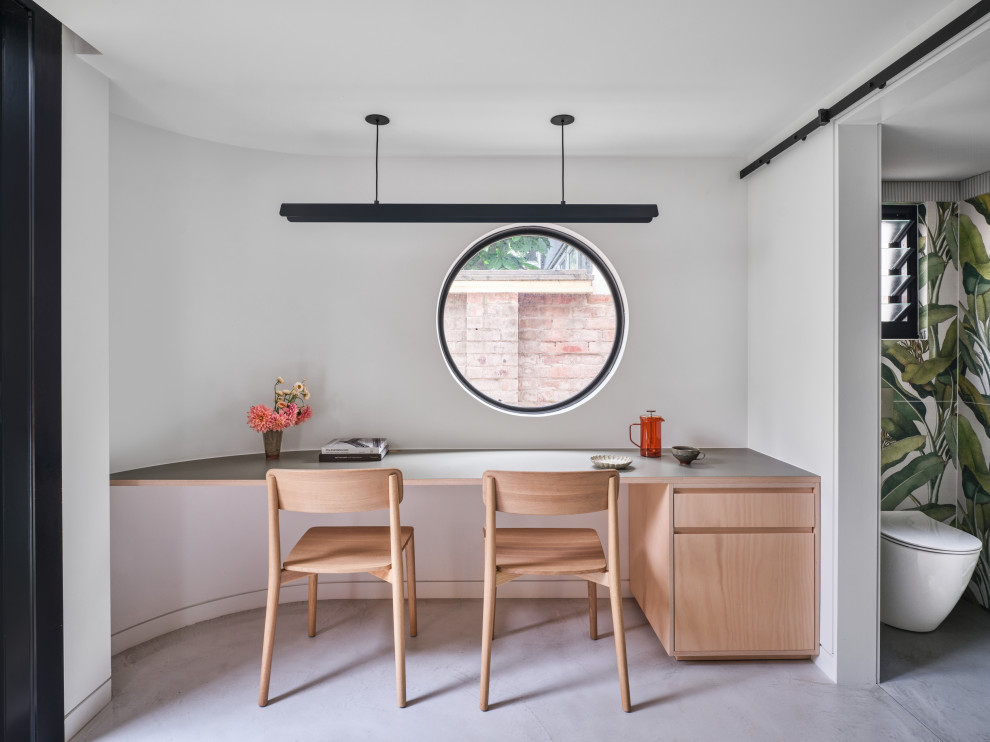 Photo of a small contemporary home office in Sydney with a built-in desk and grey floor.