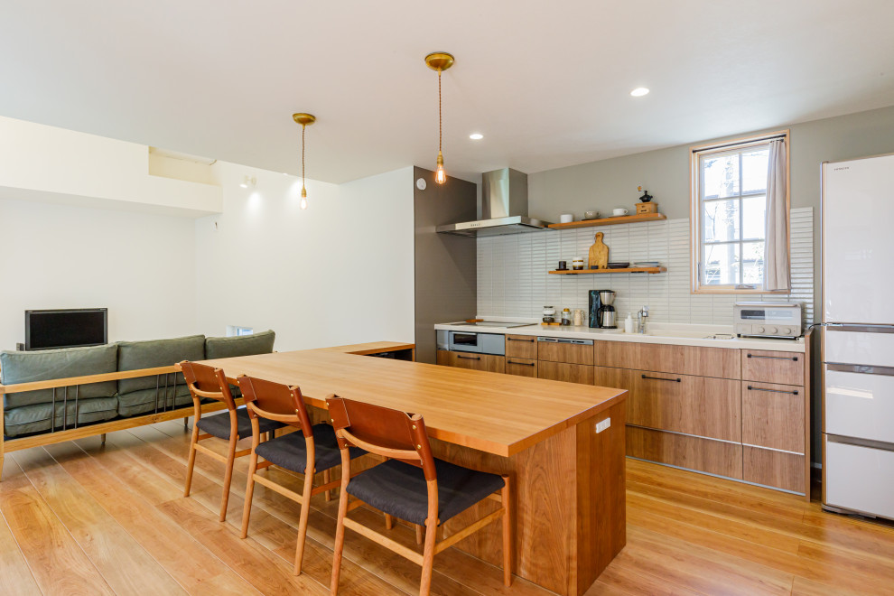 Imagen de cocina minimalista de tamaño medio abierta con suelo de madera en tonos medios, suelo marrón y papel pintado
