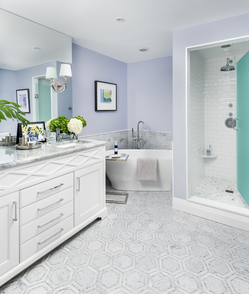 Mid-sized transitional master bathroom in Toronto with white cabinets, a freestanding tub, an alcove shower, a one-piece toilet, gray tile, metal tile, marble floors, an undermount sink, marble benchtops, grey floor, a hinged shower door, blue walls and recessed-panel cabinets.