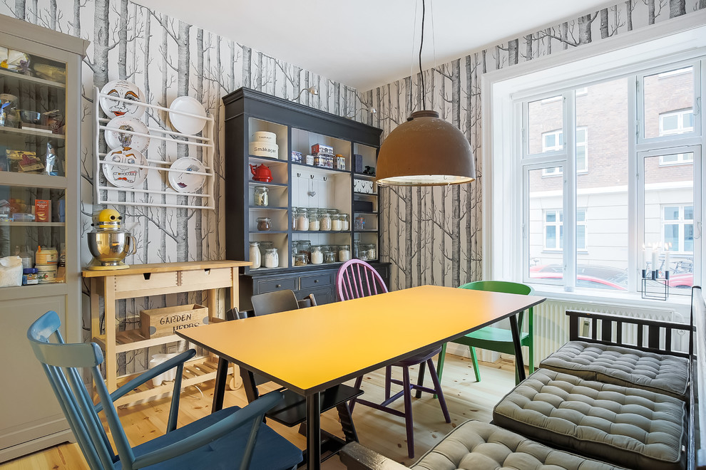 Photo of a small eclectic separate dining room in Copenhagen with light hardwood floors, multi-coloured walls and no fireplace.