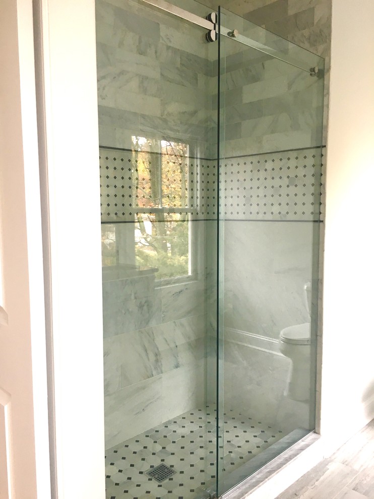 Mid-sized traditional 3/4 bathroom in Newark with an alcove shower, a one-piece toilet, gray tile, white tile, porcelain tile, beige walls, porcelain floors and marble benchtops.