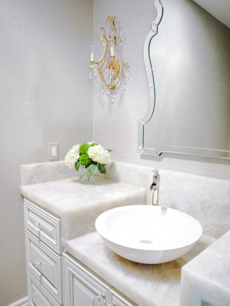 Powder room - mid-sized transitional limestone floor and wallpaper powder room idea in San Luis Obispo with raised-panel cabinets, white cabinets, a vessel sink, onyx countertops, white countertops and a built-in vanity