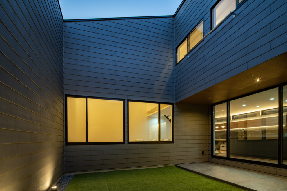 Idée de décoration pour une terrasse design de taille moyenne avec une cour, du carrelage et une extension de toiture.
