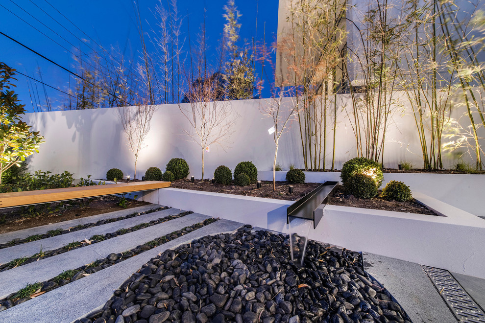 Inspiration for a contemporary front yard xeriscape in Canberra - Queanbeyan with a water feature and gravel.
