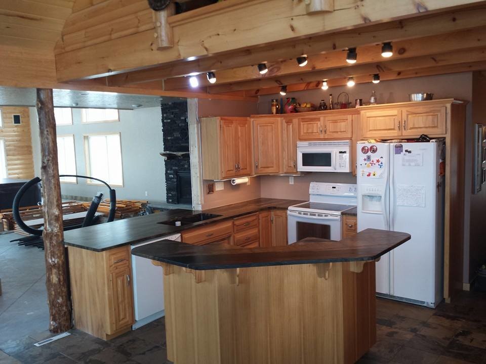 Eat-in kitchen - mid-sized rustic l-shaped slate floor eat-in kitchen idea with an undermount sink, raised-panel cabinets, light wood cabinets, quartzite countertops, white appliances and an island