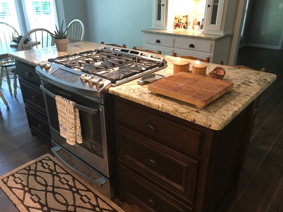 Large transitional l-shaped brown floor eat-in kitchen photo in Birmingham with a farmhouse sink, recessed-panel cabinets, white cabinets, beige backsplash, stainless steel appliances and an island