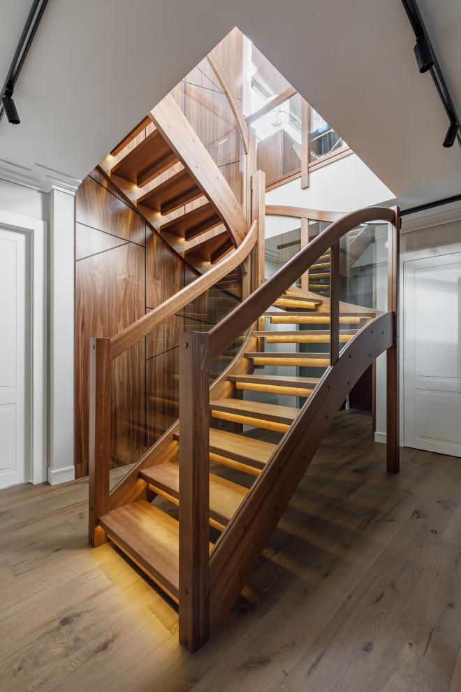 Foto de escalera curva contemporánea sin contrahuella con escalones de madera y barandilla de varios materiales