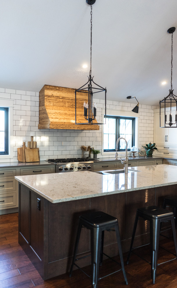 Photo of a large transitional u-shaped open plan kitchen in Other with a farmhouse sink, recessed-panel cabinets, white cabinets, quartz benchtops, multi-coloured splashback, subway tile splashback, stainless steel appliances, dark hardwood floors and with island.