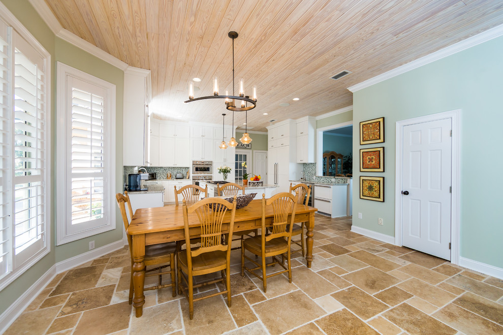 Beach style dining room in Jacksonville with travertine floors.