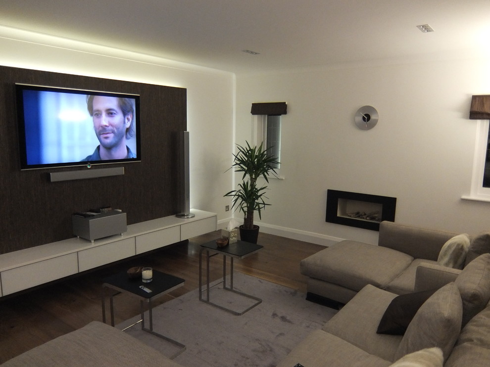 Photo of a modern living room in London with dark hardwood floors and a wall-mounted tv.