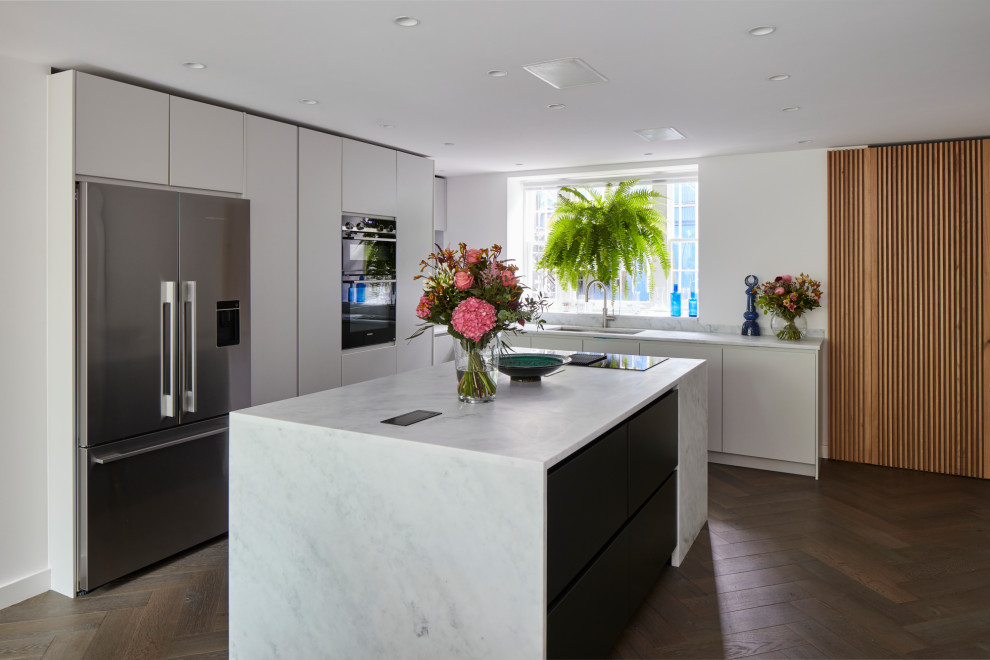 На фото: угловая кухня-гостиная среднего размера в современном стиле с плоскими фасадами и островом с
