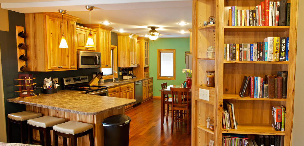Open concept kitchen - small galley open concept kitchen idea with a drop-in sink, raised-panel cabinets, light wood cabinets, laminate countertops, stainless steel appliances and a peninsula