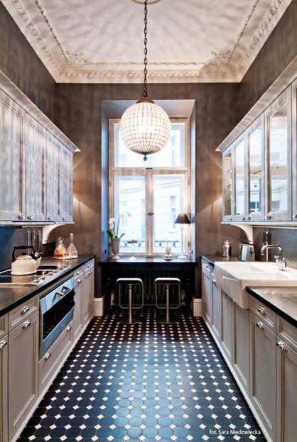 Inspiration for a mid-sized traditional kitchen in New York with porcelain floors, a farmhouse sink, glass-front cabinets, white cabinets, marble benchtops, window splashback, stainless steel appliances and black floor.